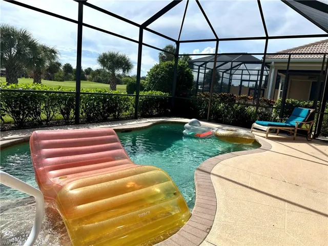 View of swimming pool featuring a patio and a lanai