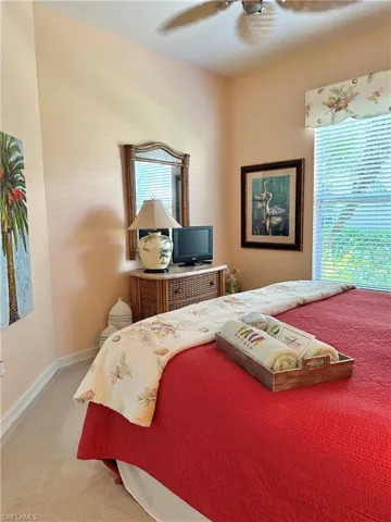 Bedroom featuring multiple windows, ceiling fan, and carpet flooring