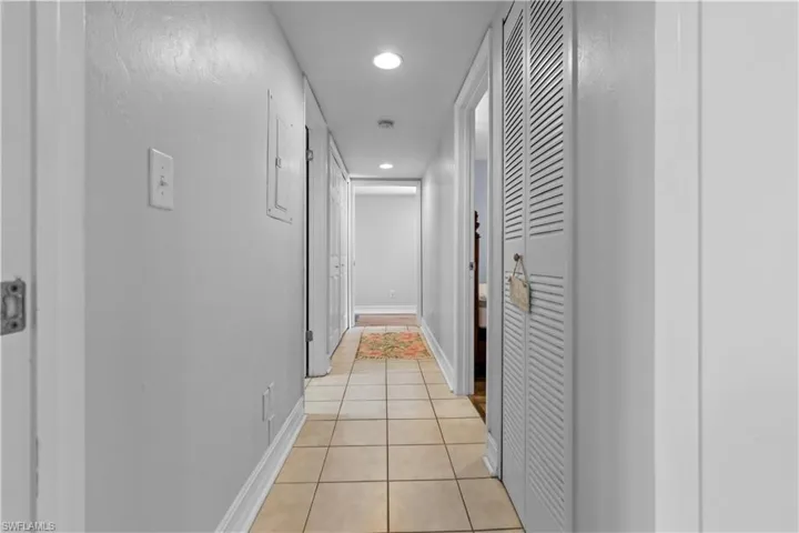 Hallway leading the the laundry area, guest bath and bedroom with the primary ensuite at the end of the hall