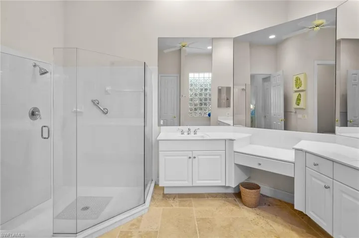 Full bath with ceiling fan, a shower stall, and vanity