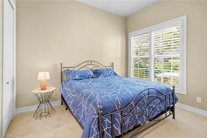 Carpeted bedroom featuring a closet and baseboards