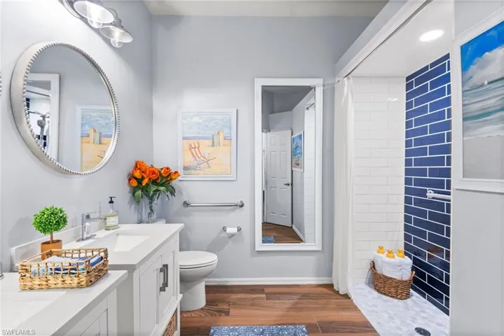 Bathroom featuring hardwood / wood-style floors, toilet, a shower with shower curtain, and vanity