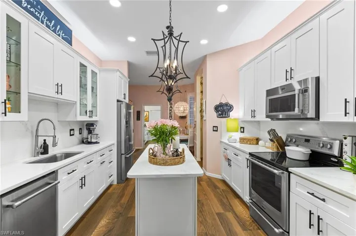 Kitchen with white cabinetry, stainless steel appliances, sink, and dark hardwood / wood-style flooring