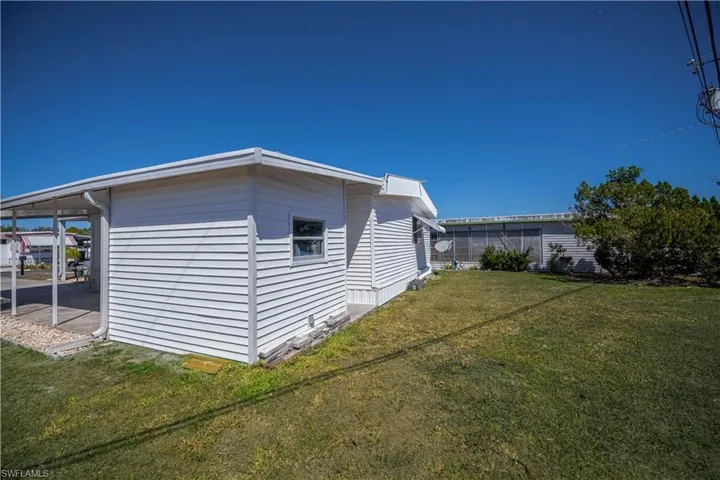 View of property exterior with a yard