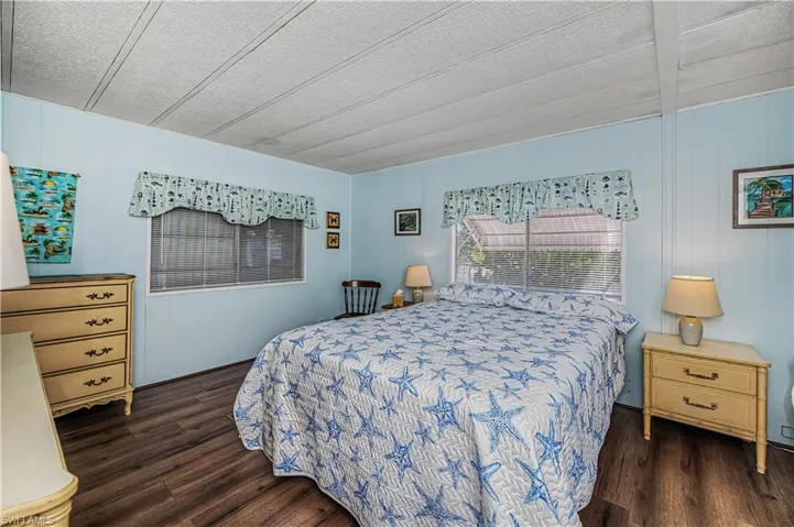 Bedroom featuring dark wood-type flooring and wood walls