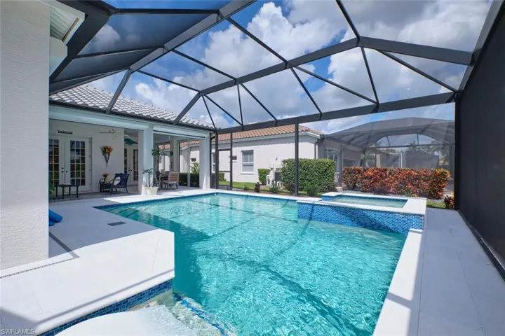 View of pool with french doors, ceiling fan, a lanai, an in ground hot tub, and a patio