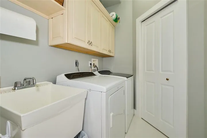 Laundry room with cabinets, sink, and washer and dryer