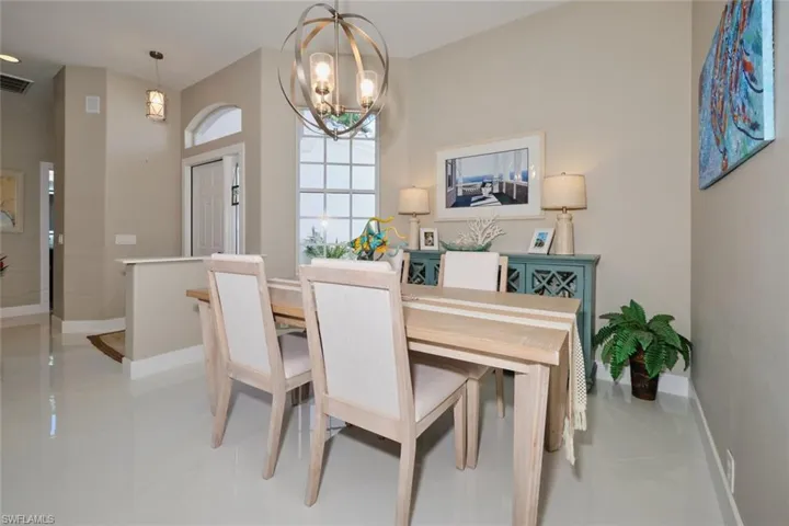 Dining area with light tile patterned floors and an inviting chandelier
