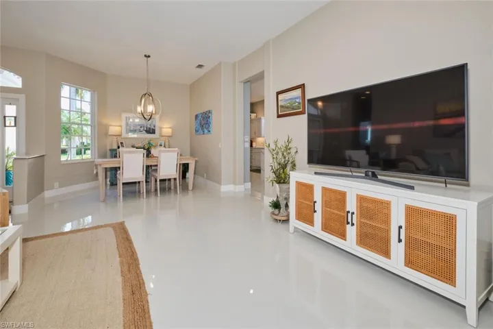 Living room with tile patterned floors and a notable chandelier