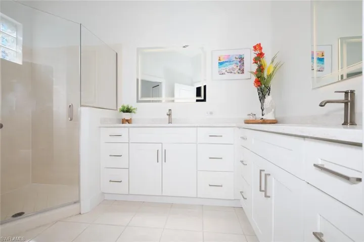 Bathroom with tile patterned flooring, vanity, and an enclosed shower