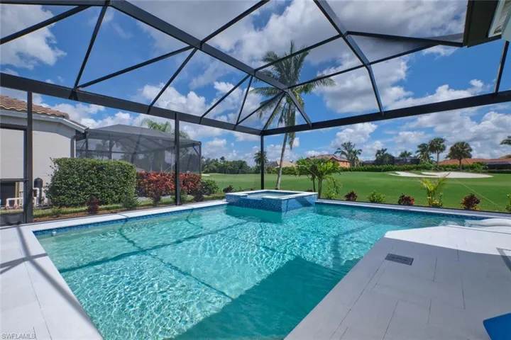 View of swimming pool with a lanai, a patio, and an in ground hot tub