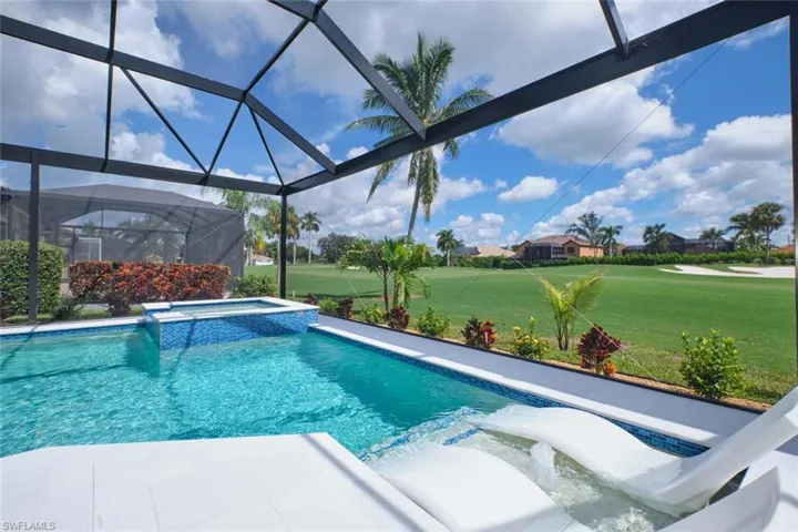 View of pool featuring a lawn, a lanai, and an in ground hot tub