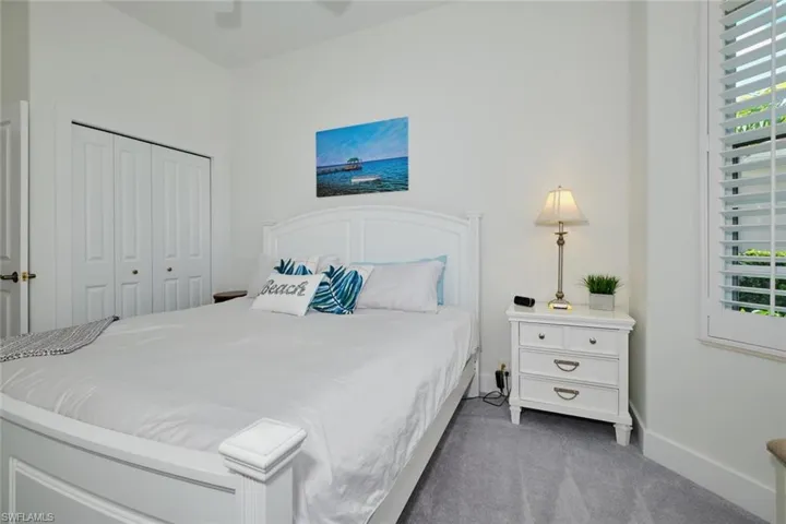 Carpeted bedroom featuring ceiling fan and a closet