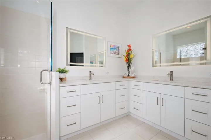 Bathroom featuring tile patterned flooring, vanity, and an enclosed shower