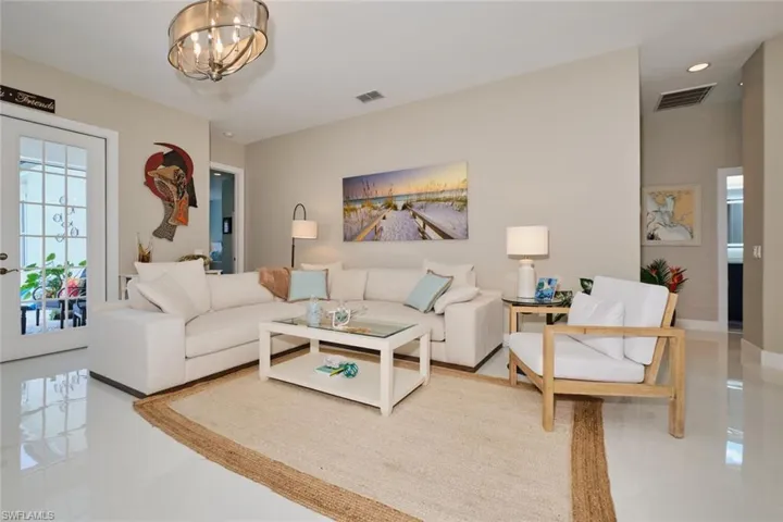 Living room featuring light tile patterned floors and an inviting chandelier