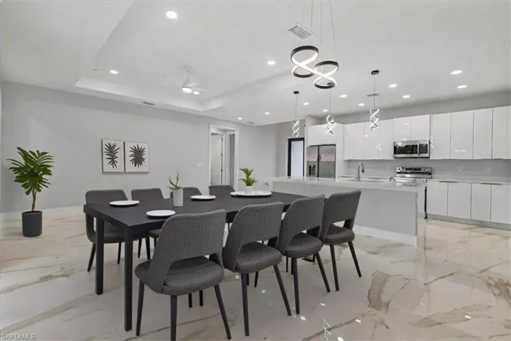 Dining space with ceiling fan, a tray ceiling, and sink