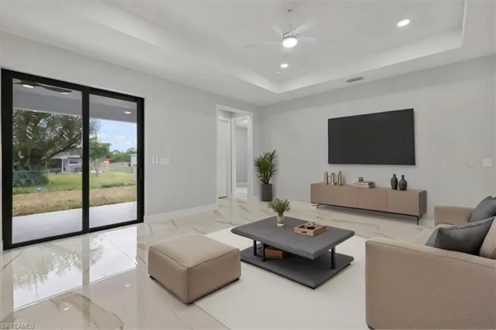 Living room with ceiling fan and a raised ceiling