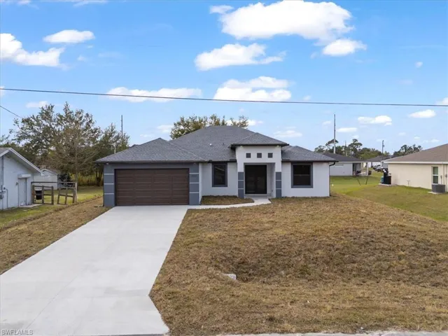 View of front of property featuring a front yard and a garage
