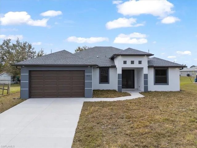 View of front facade featuring a garage and a front yard