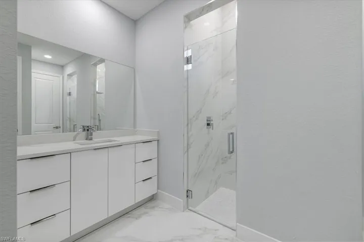 Bathroom featuring vanity and a shower with door