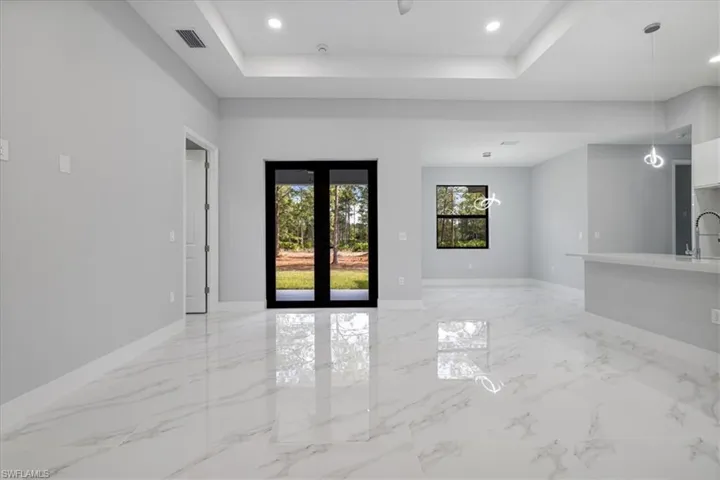 Unfurnished room with a raised ceiling, french doors, and sink
