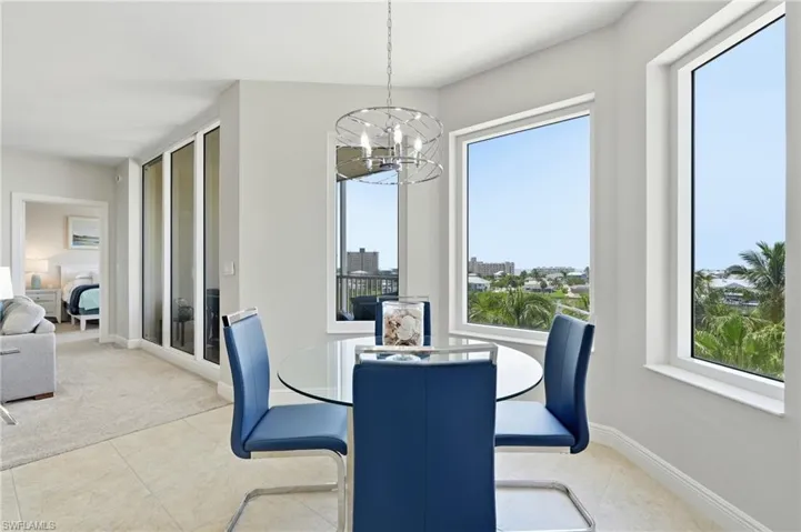 Dining area featuring tile flooring, a chrome-finish chandelier, and multiple windows