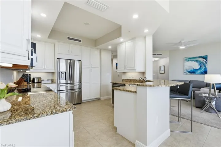 Kitchen featuring white cabinetry, stainless steel appliances, and granite countertops