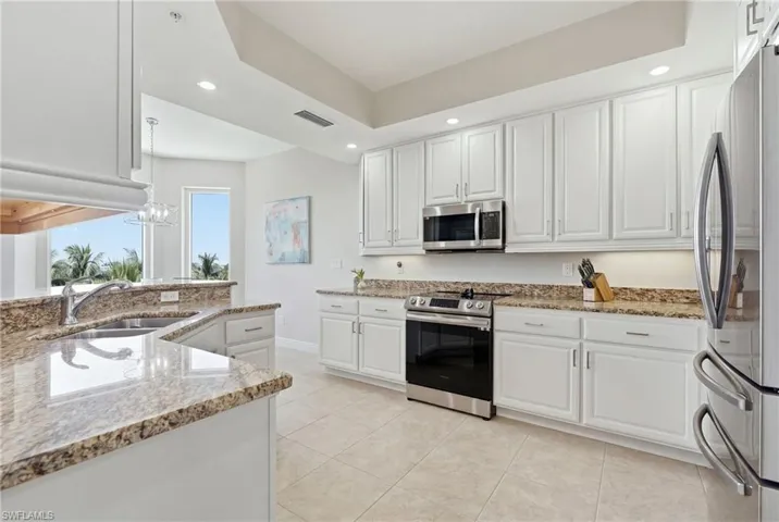 Kitchen featuring white cabinetry, stainless steel appliances, granite countertops, and tiled flooring