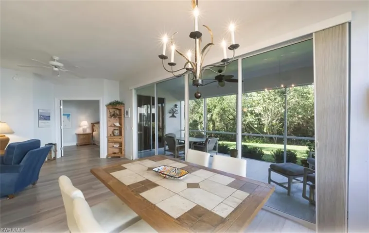 Dining area with a ceiling fan, wood finished floors, and a chandelier