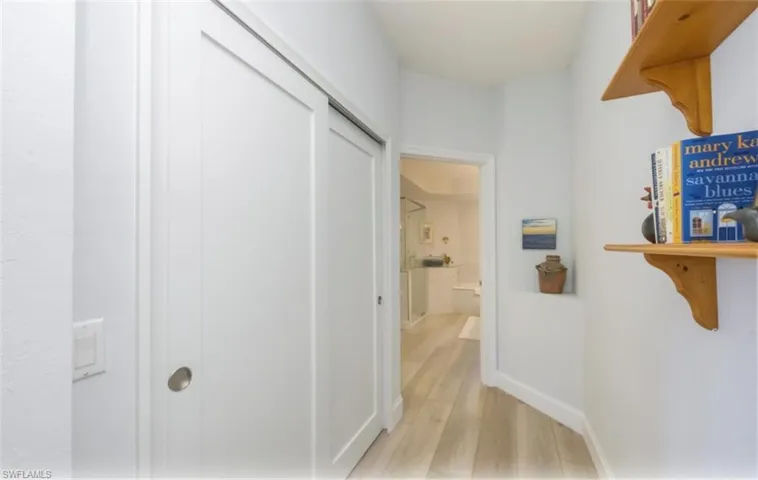 Corridor with light wood-style floors and baseboards
