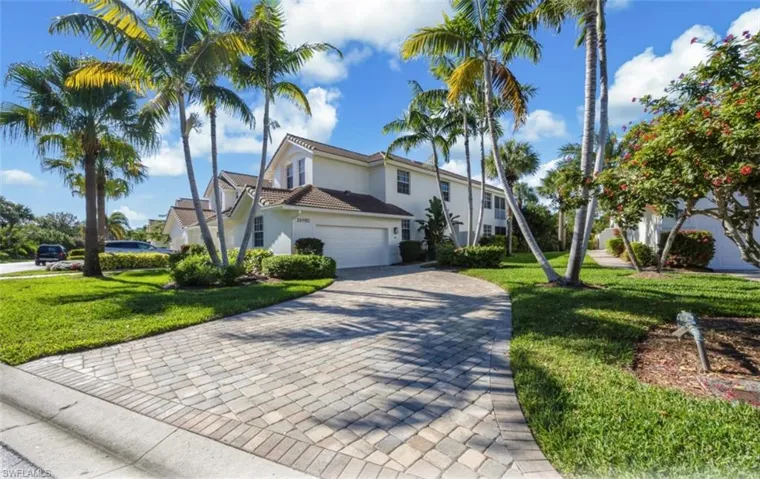 View of front of home featuring a front yard, decorative driveway, a garage, and stucco siding