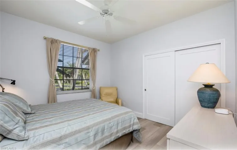 Bedroom featuring light wood-style floors, ceiling fan, and a closet