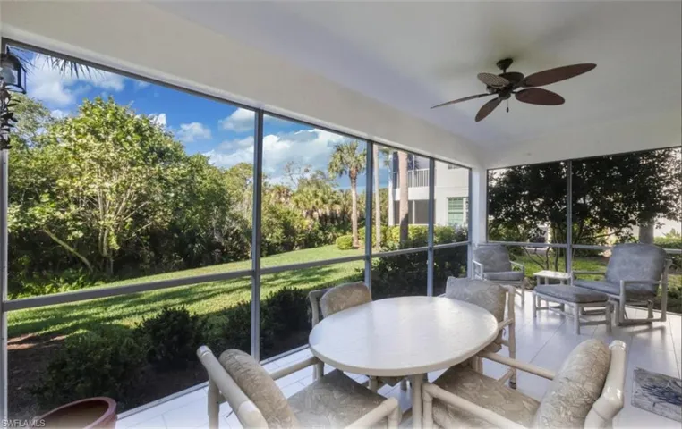 Sunroom / solarium featuring tile patterned flooring and view of scattered trees