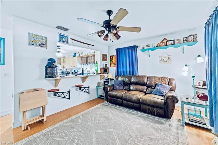 Living room featuring ceiling fan and light hardwood / wood-style flooring