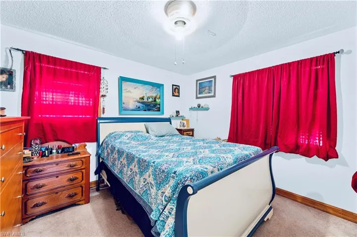 Bedroom with carpet flooring, ceiling fan, and a textured ceiling