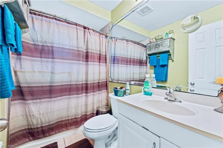 Bathroom with tile floors, large vanity, and toilet