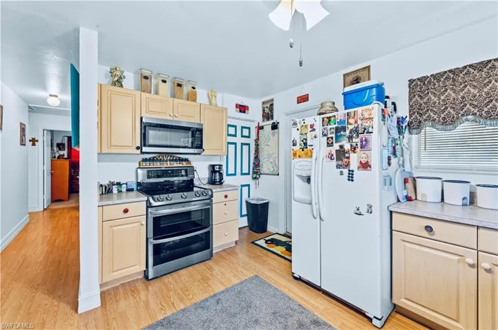 Kitchen with stainless steel appliances, ceiling fan, light hardwood / wood-style floors, and light brown cabinets