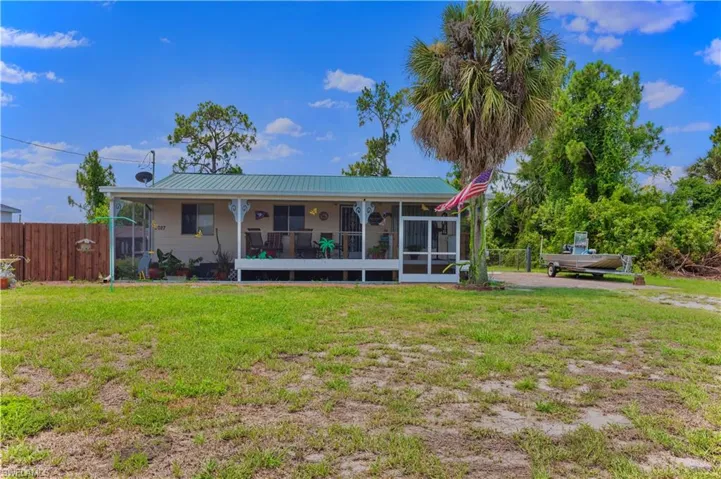 Back of property featuring a sunroom and a lawn