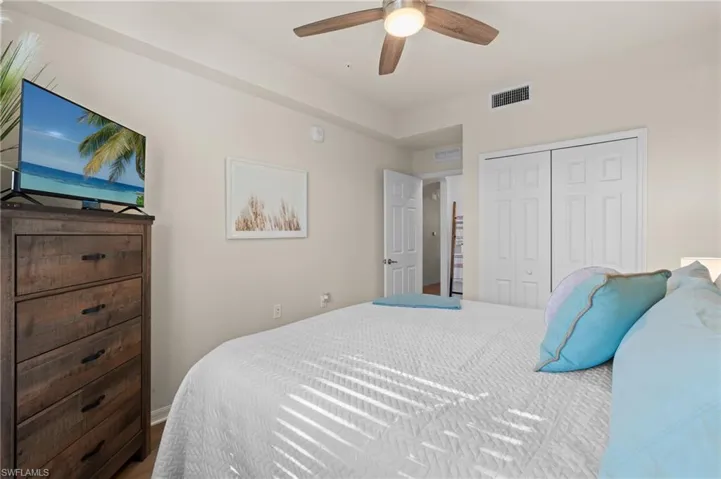 Bedroom with a ceiling fan, visible vents, and a closet