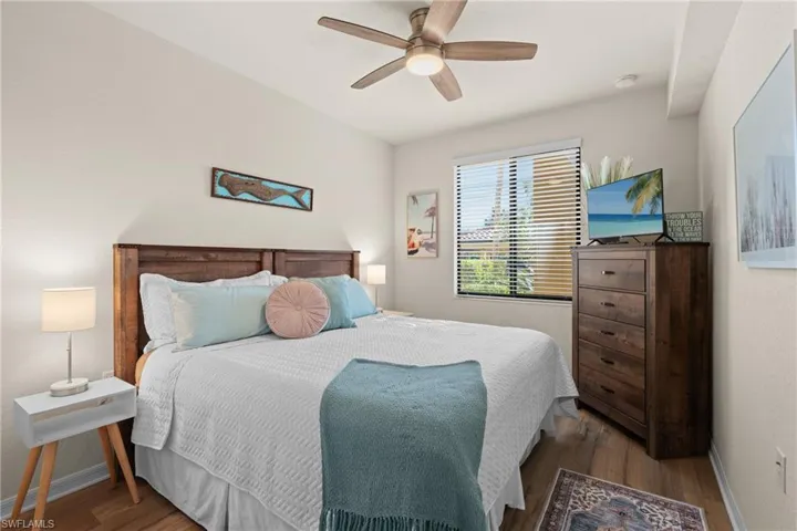 Bedroom featuring a ceiling fan, light wood-style flooring, and baseboards