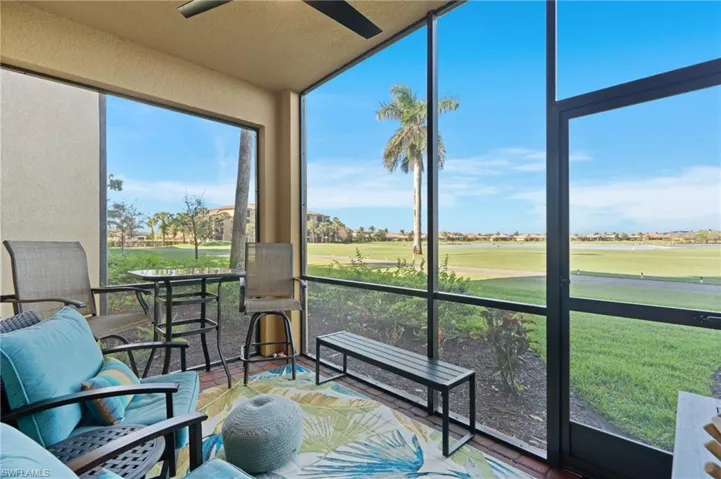 Sunroom with view of golf course and ceiling fan