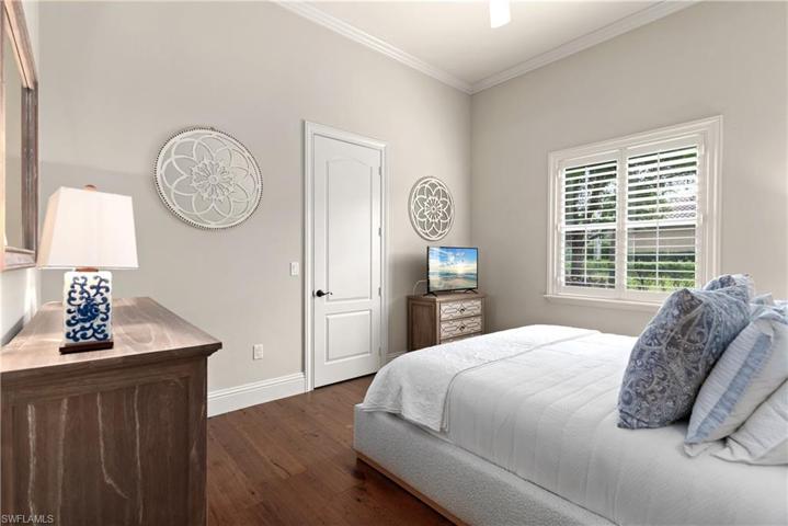 King size bedroom with wood flooring, walk-in closet, crown molding and Plantation Shutters.
