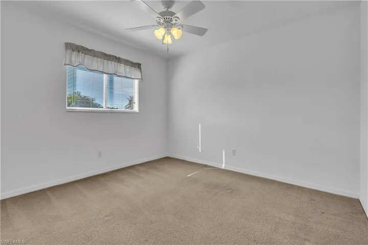 Spare room featuring light carpet and a ceiling fan