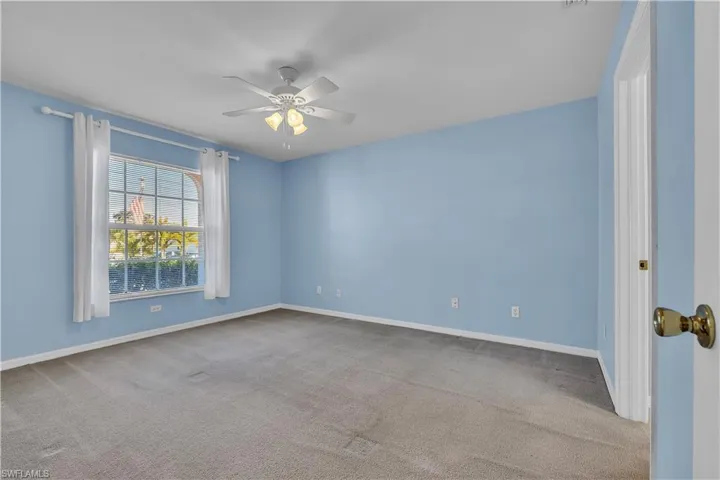 Unfurnished room featuring light colored carpet and ceiling fan