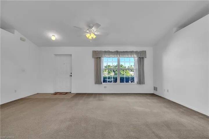 Unfurnished room featuring a ceiling fan and light colored carpet