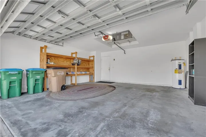 Garage featuring water heater and a garage door opener