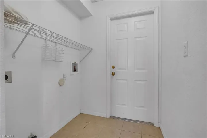 Laundry area featuring hookup for an electric dryer, light tile patterned floors, and hookup for a washing machine