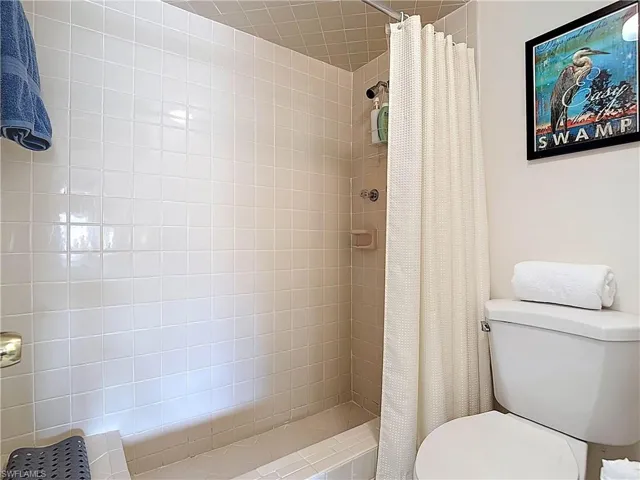 The property has a shower with light-colored square tiles and a built-in bench