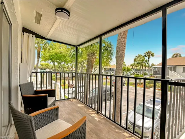 The property features a covered balcony with wood-look flooring and a black metal railing