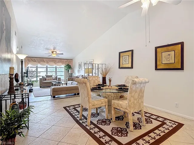 The property features vaulted ceilings, tile flooring, and a dining area with a glass-top table